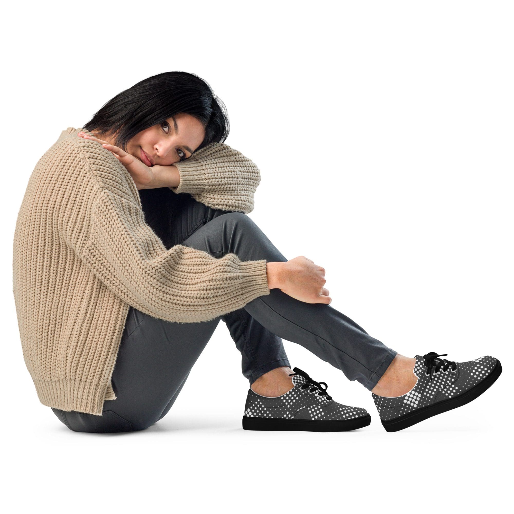 Woman sitting, wearing cozy sweater and shoes.