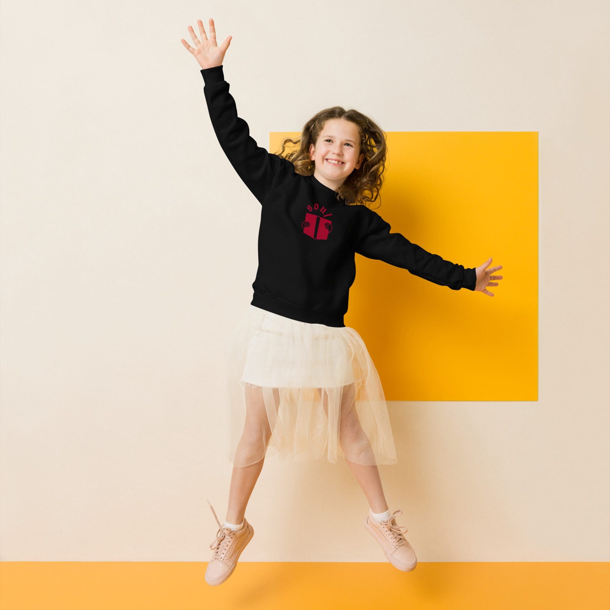 Girl jumping in front of yellow background.