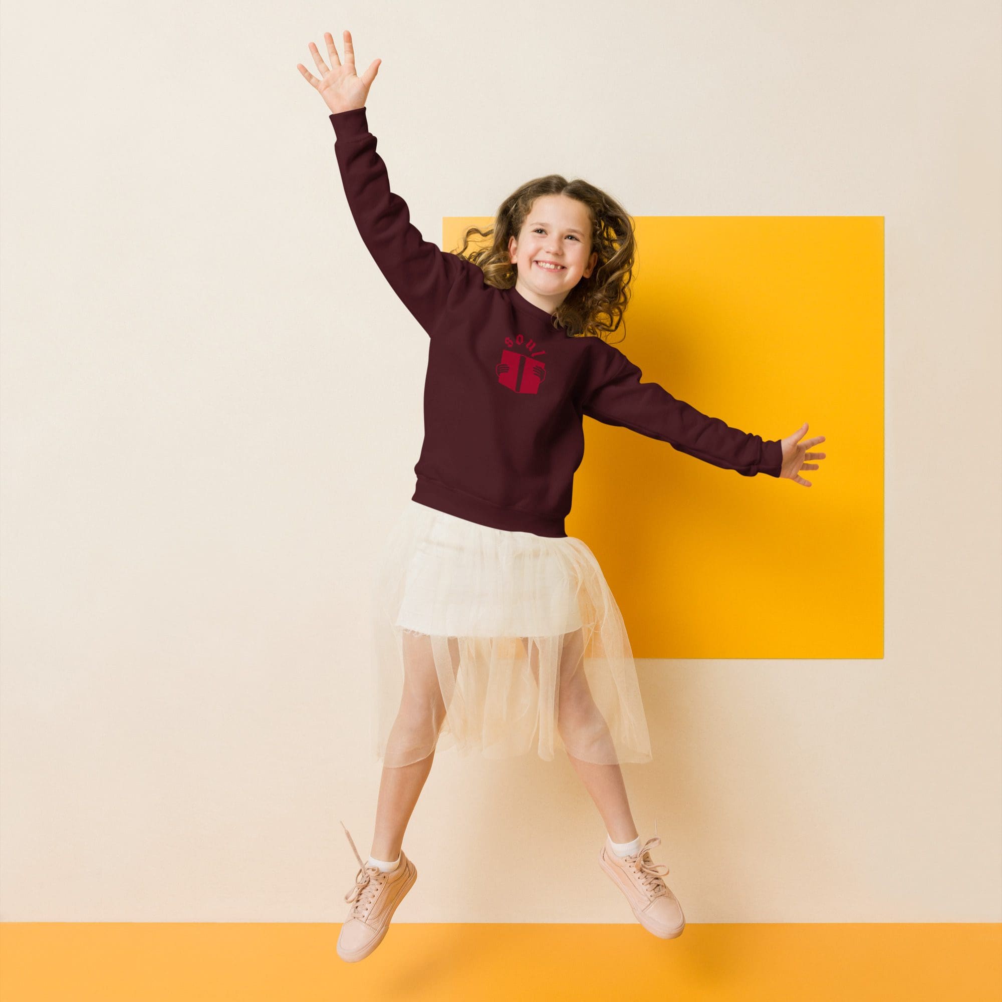 Smiling girl jumping in hoodie and tulle skirt