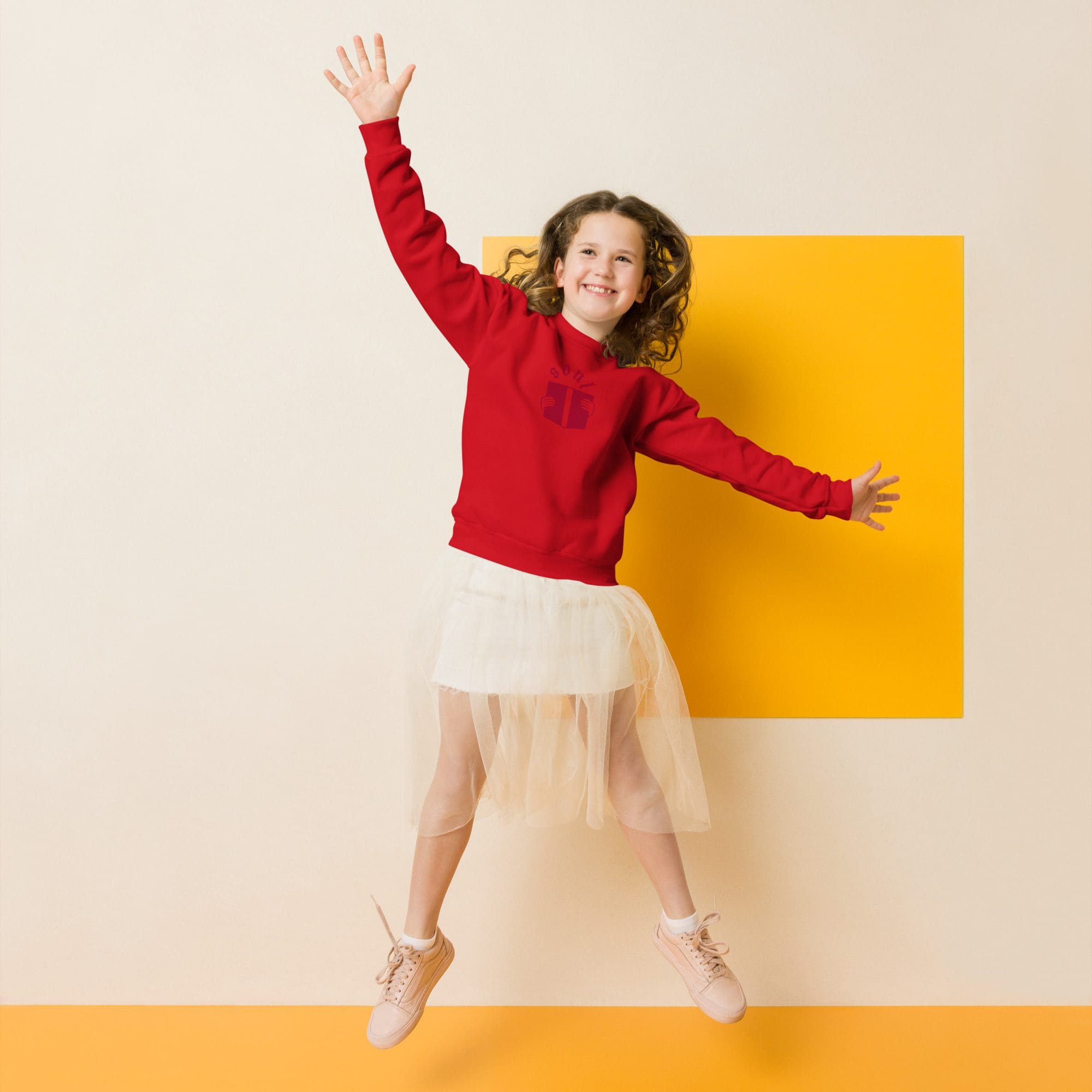 Girl jumping in red sweater and skirt.