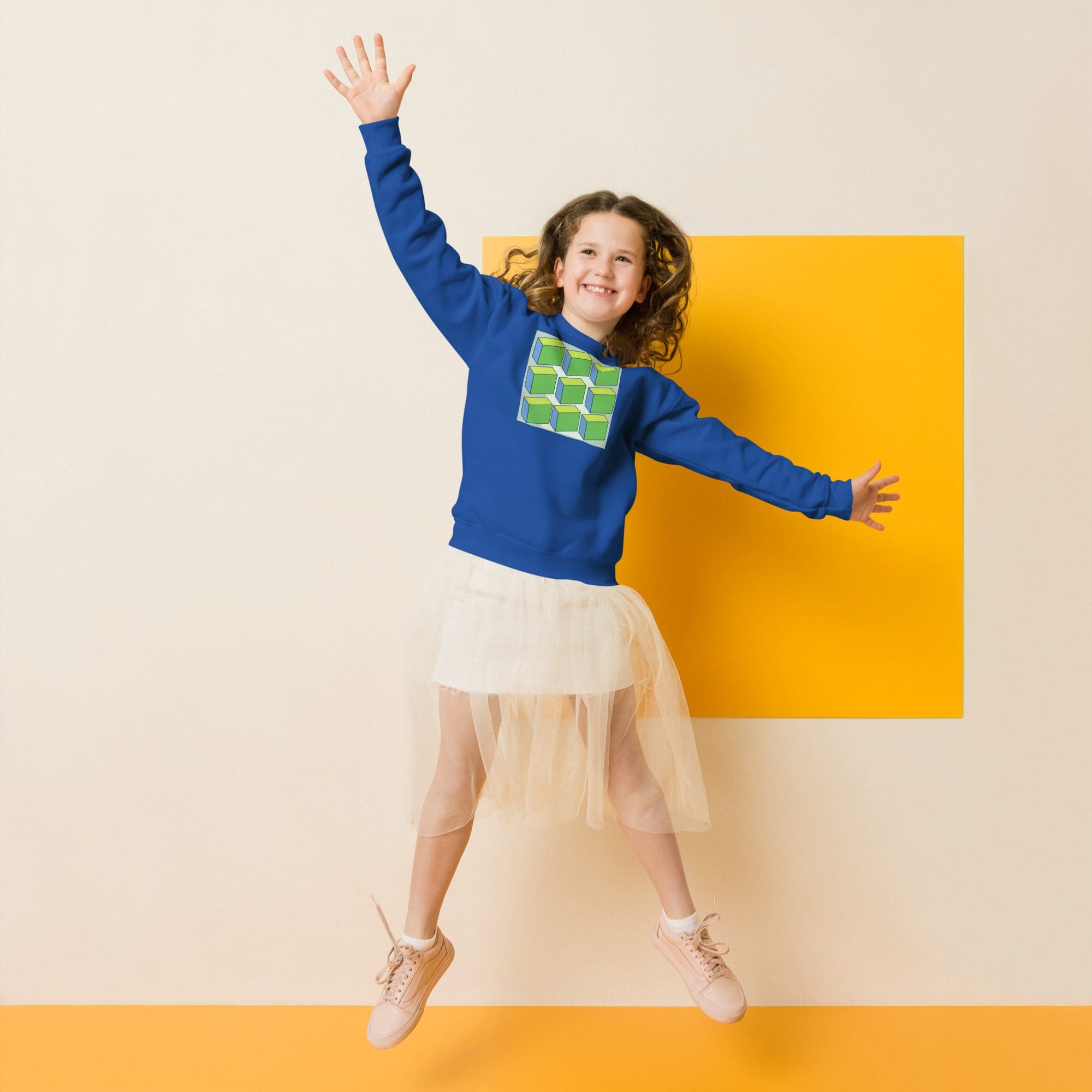 Girl jumping in blue sweatshirt, tulle skirt.