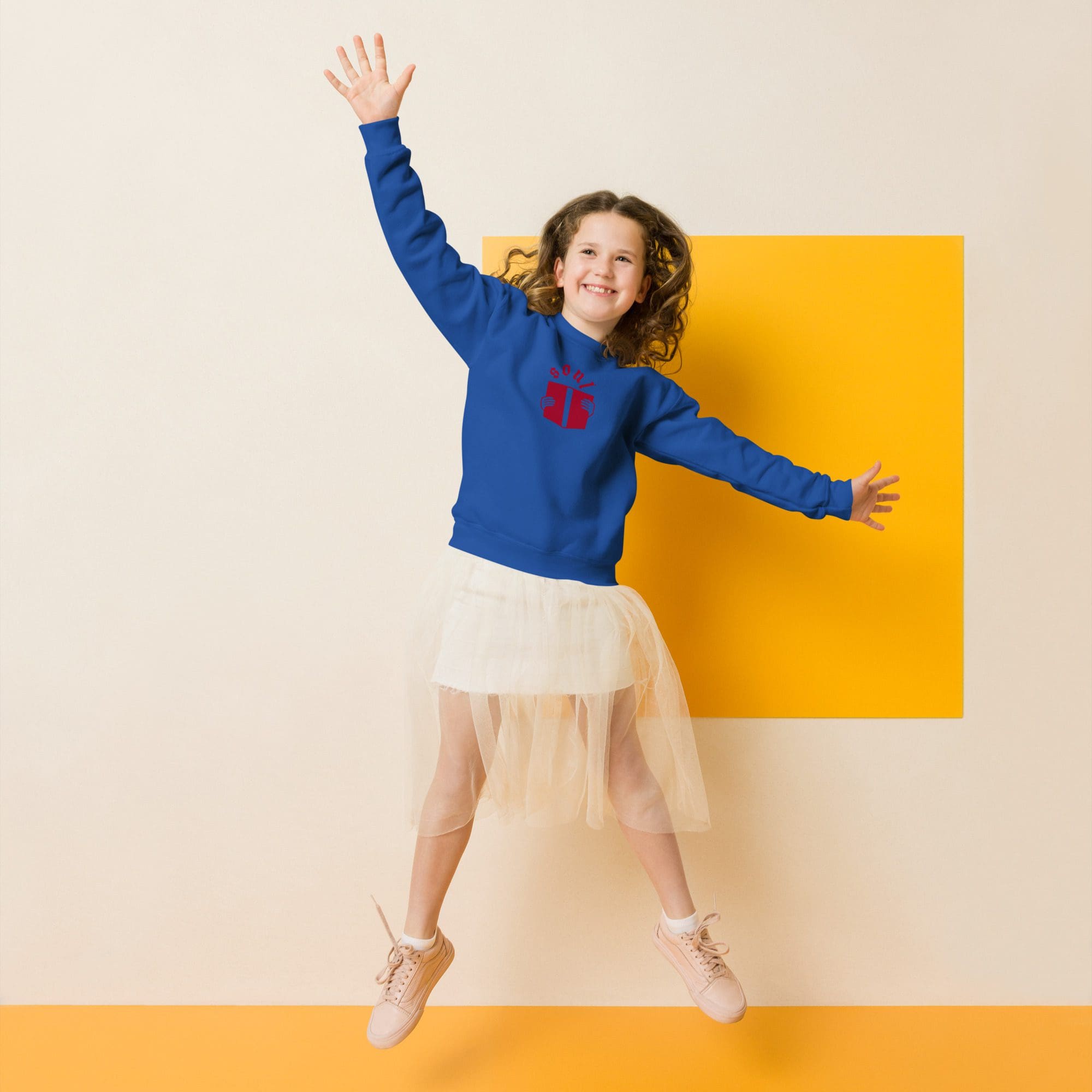 Child jumping happily against a yellow background.