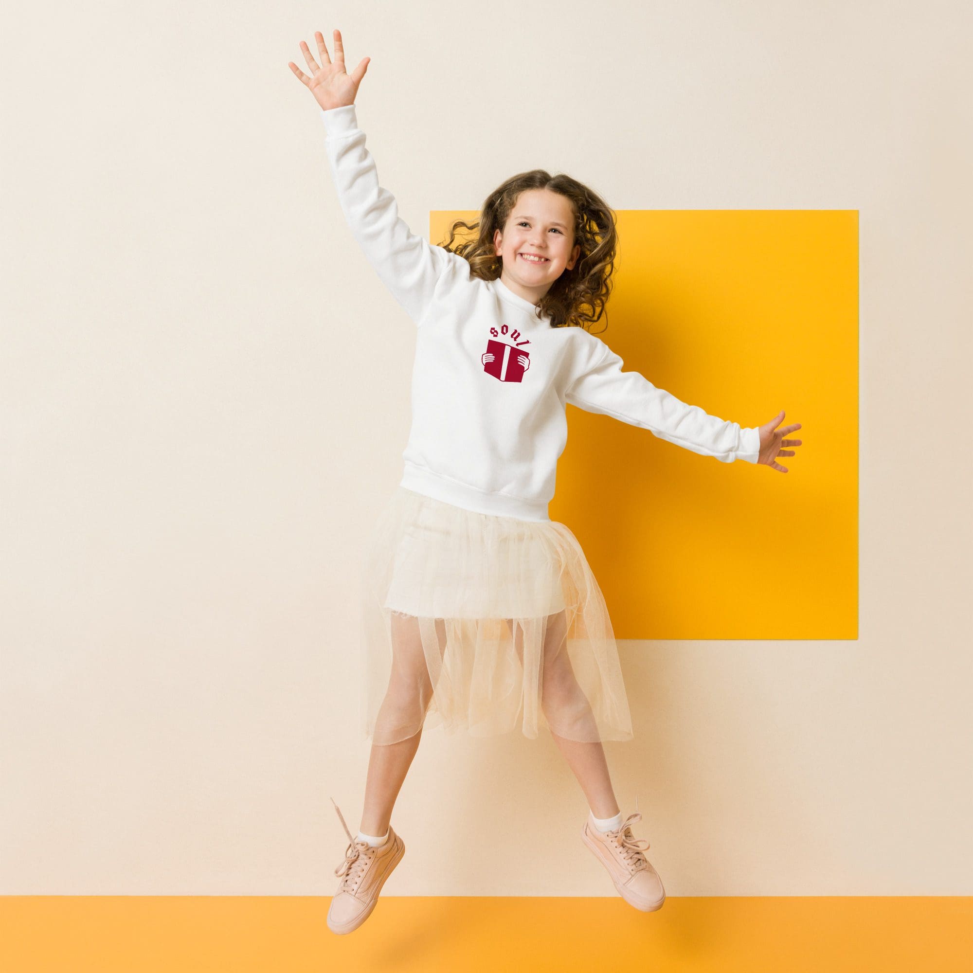Girl jumping joyfully against yellow background.