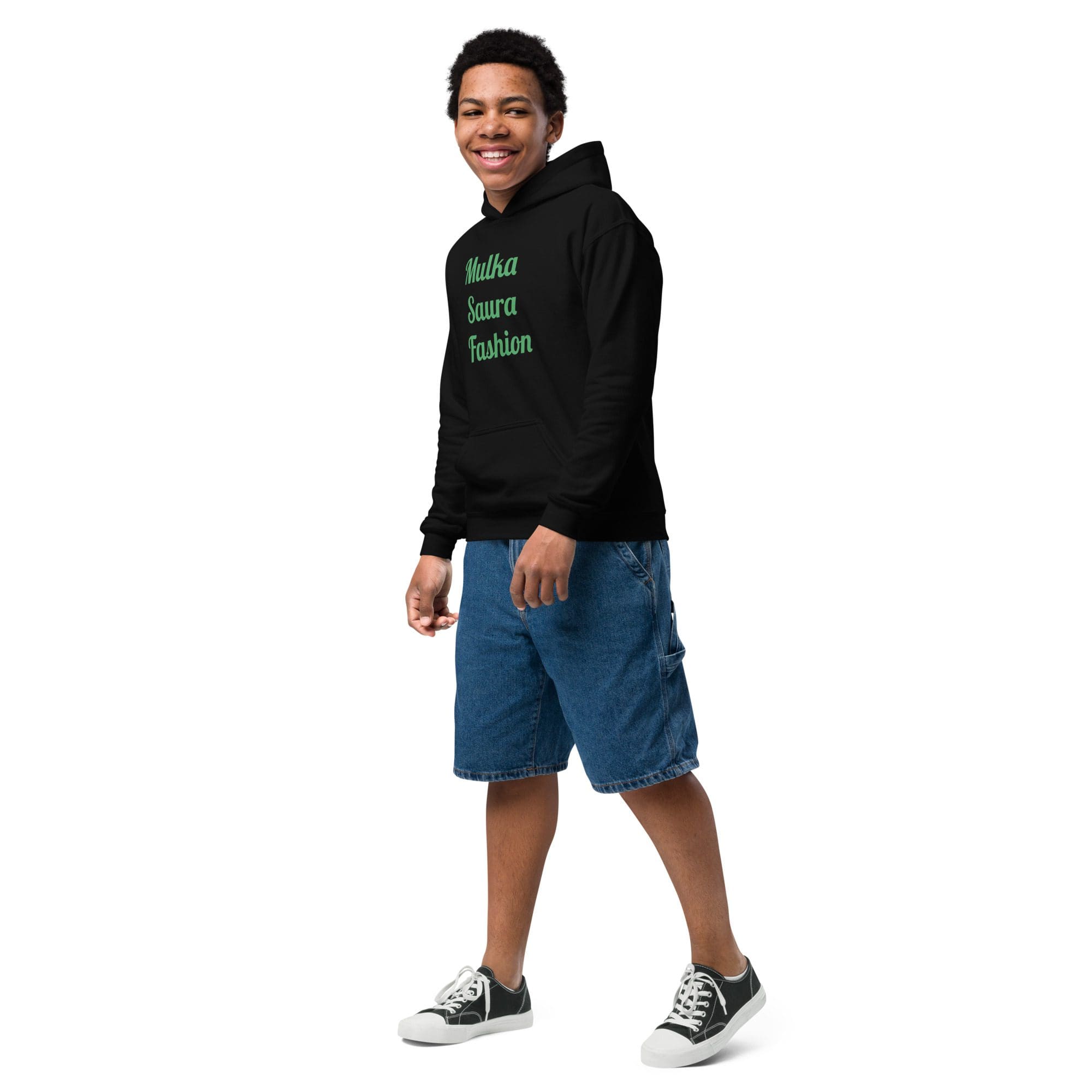 Smiling person in hoodie and denim shorts.