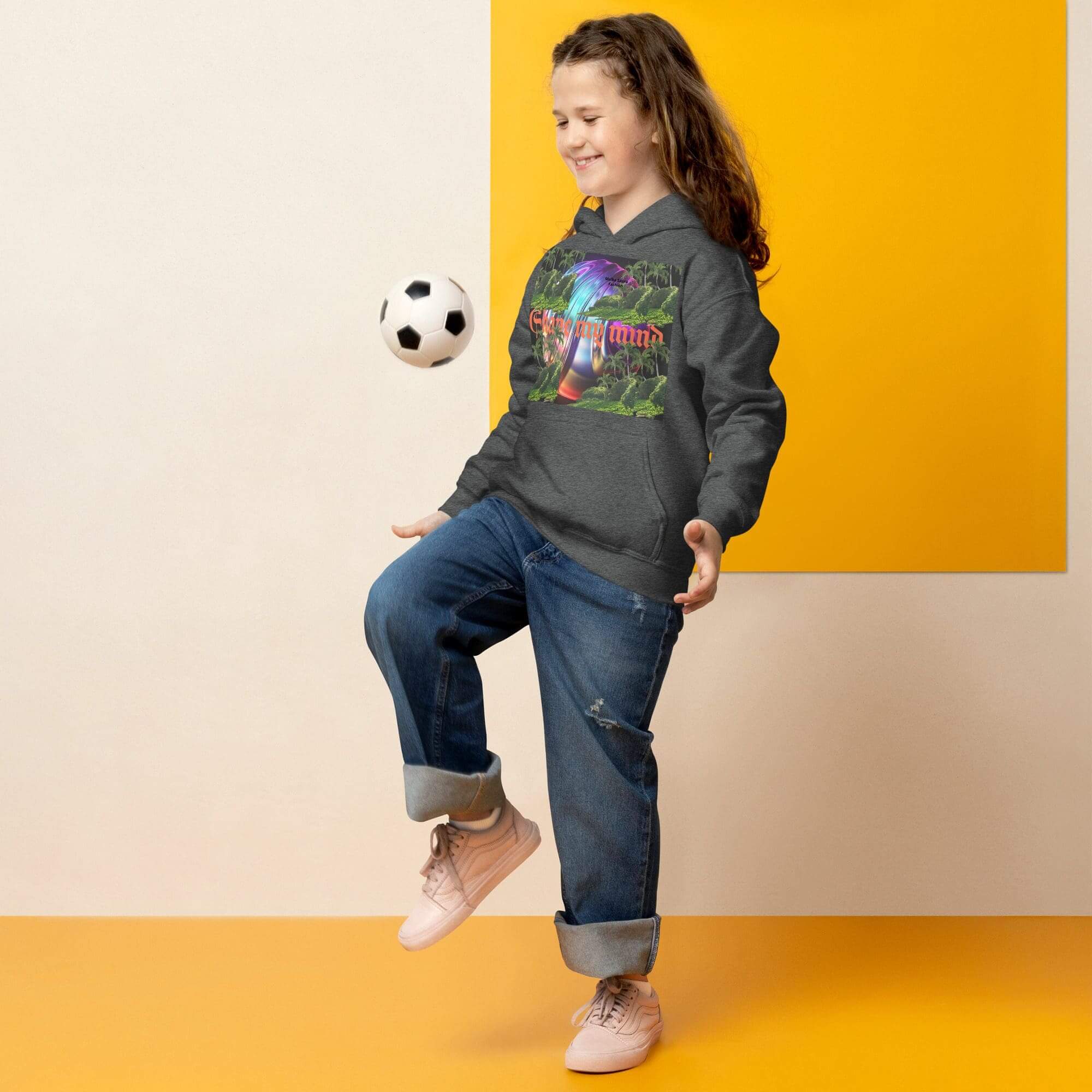 Child juggling soccer ball indoors, smiling.