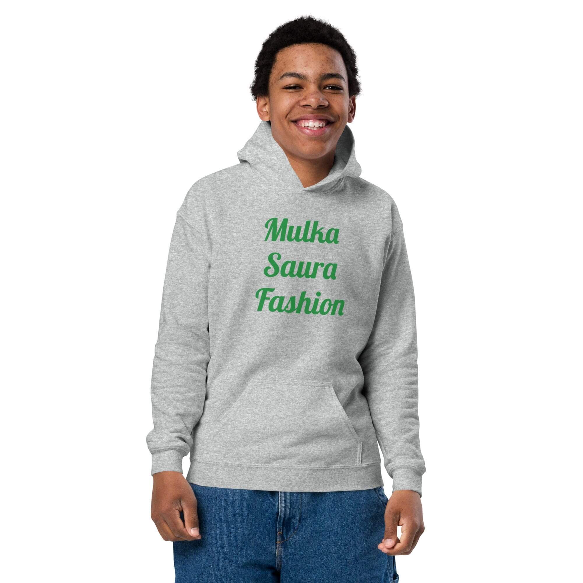 Smiling person wearing gray hoodie and jeans.
