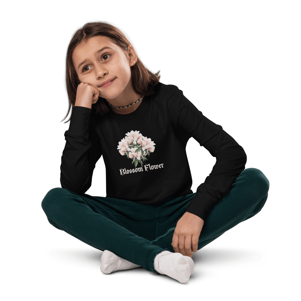 Girl sitting cross-legged, wearing floral shirt.