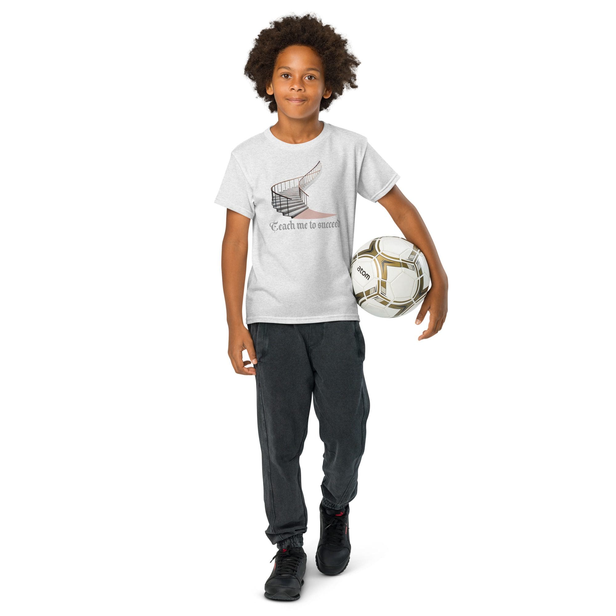 Boy holding soccer ball, wearing casual outfit.