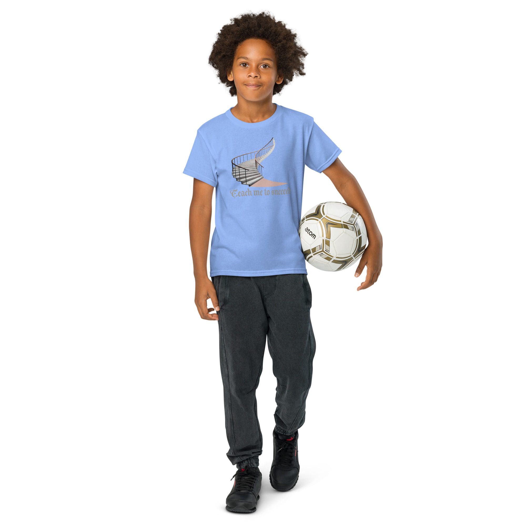 Boy holding soccer ball, wearing blue shirt.