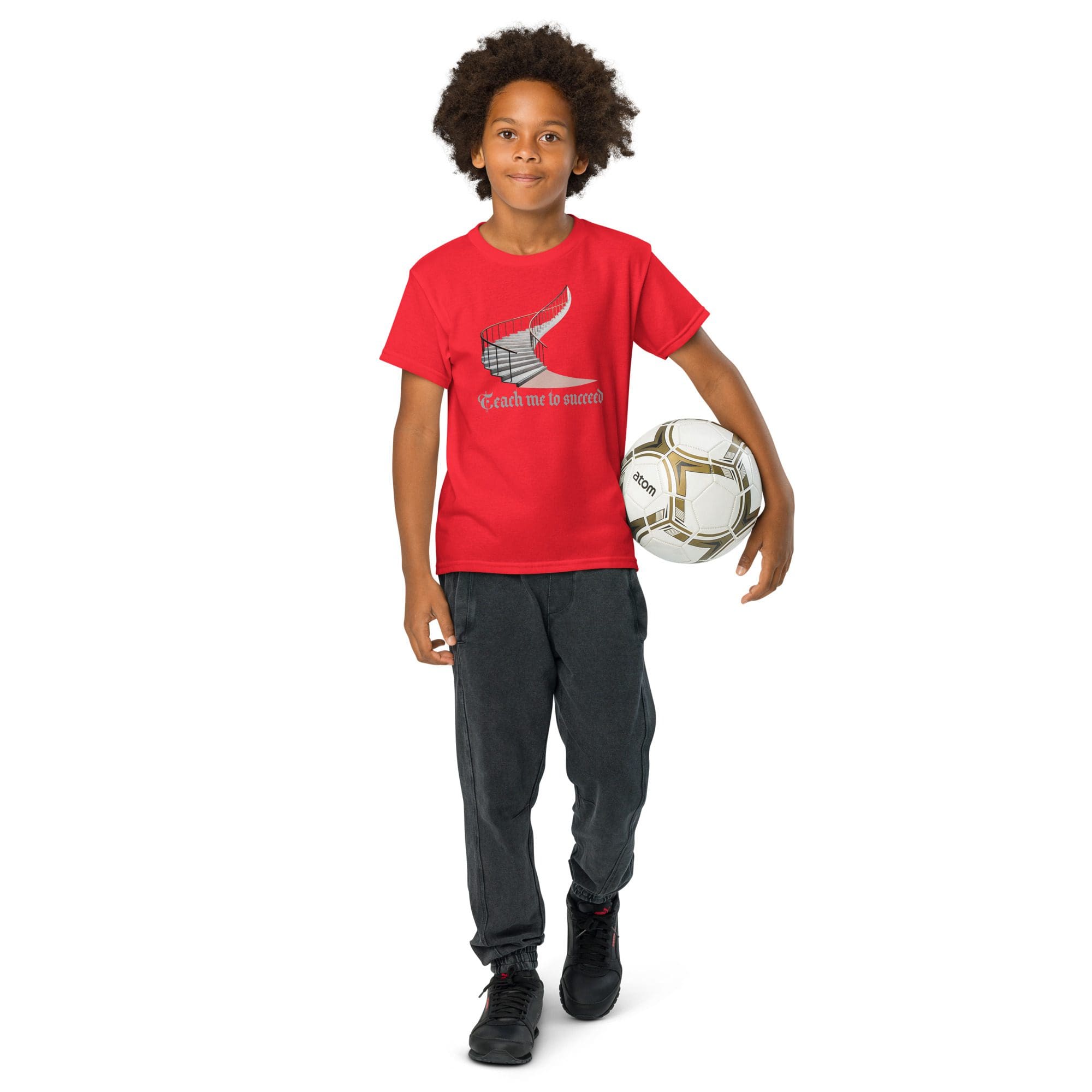 Child holding soccer ball, wearing red shirt.